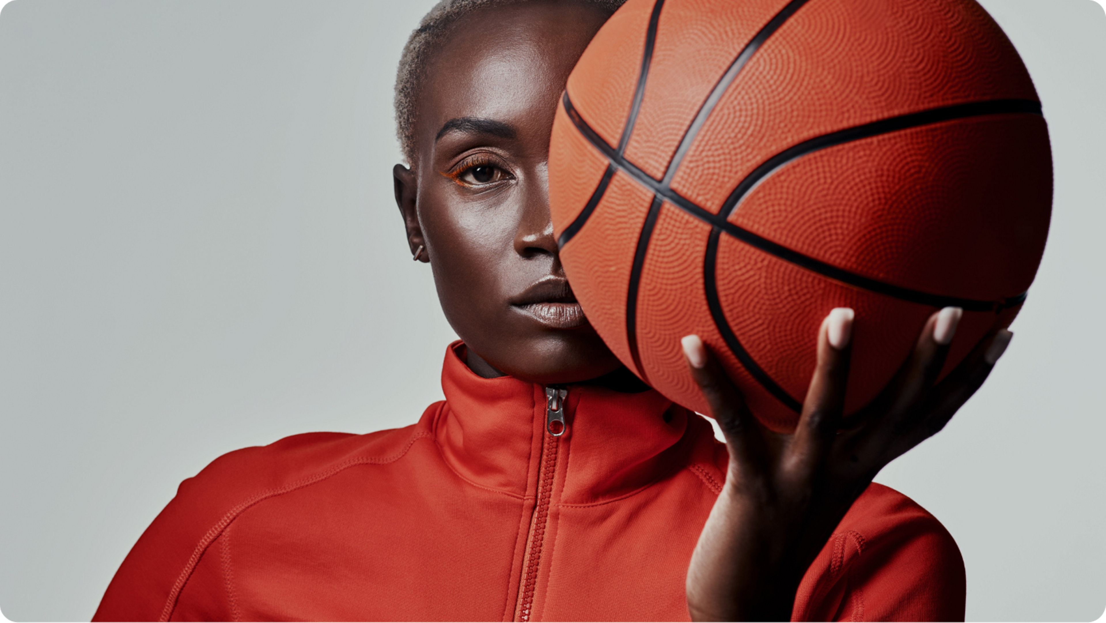 woman wearing orange sweater, holding a ball